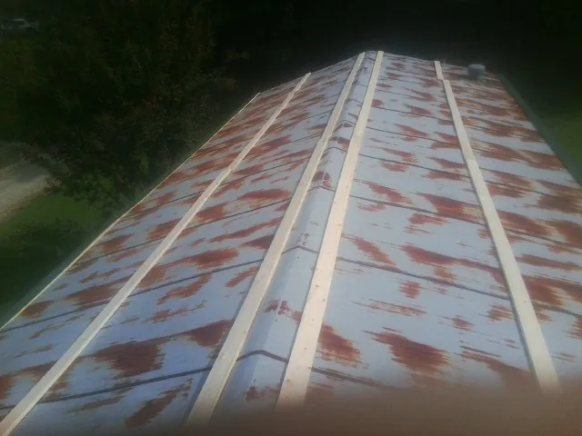 Rusted metal roof panels with new wood purlins before replacement — Storm Damage Roof Repair in Byron Center by Roofing Brothers