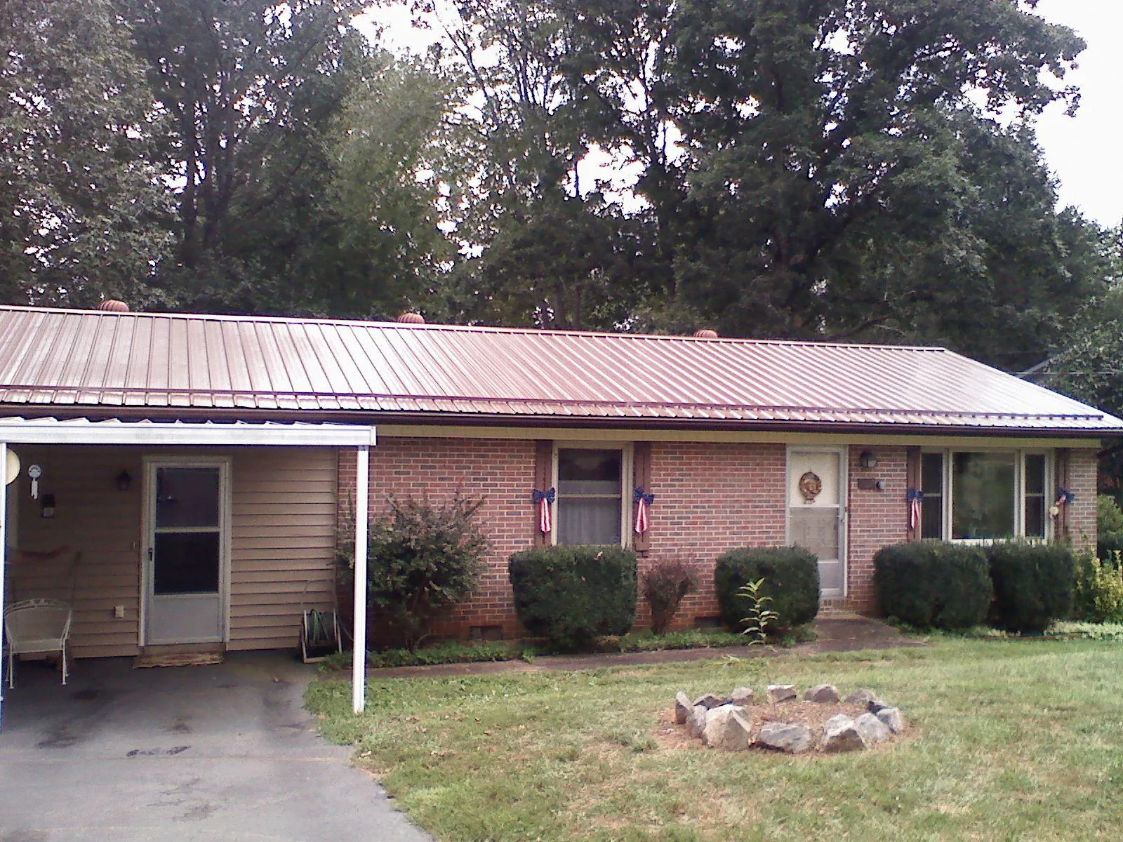 Bronze metal roof and carport on a brick ranch home — Roof Repair work by our crew in Byron Center