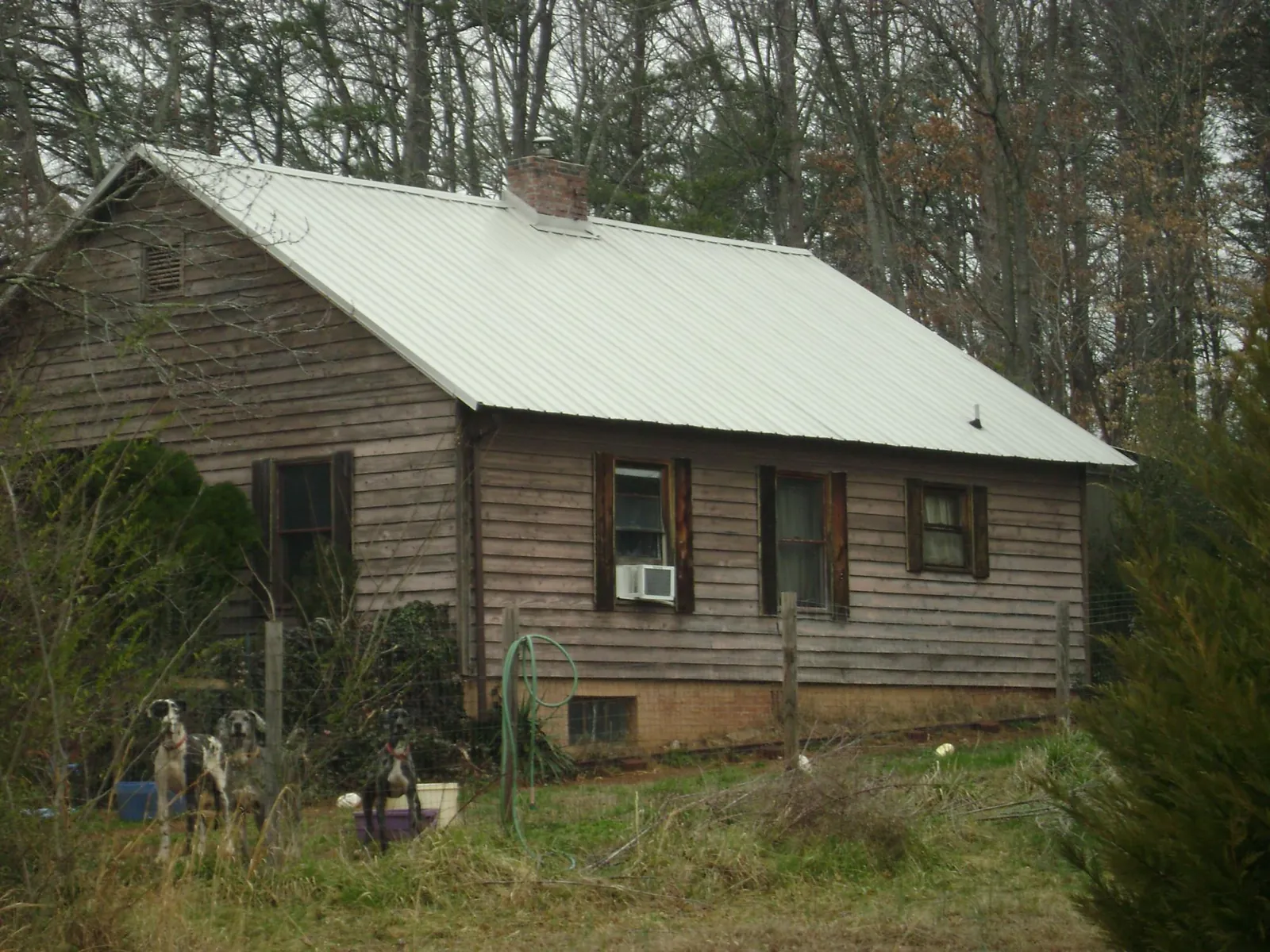 White metal roof on an old wood sided farmhouse, from a Metal Roof Installation job in Byron Center